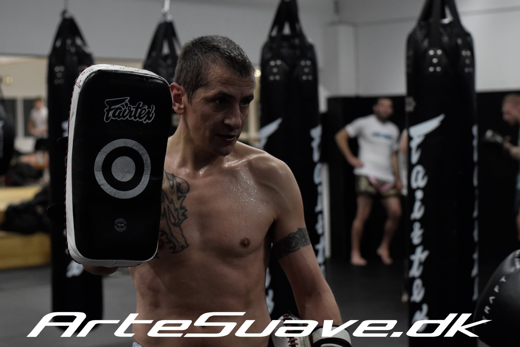 Dennis Købke holding a striking pad during training at Arte Suave.